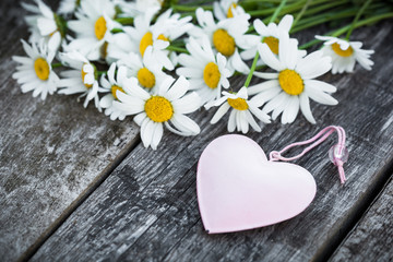 Naklejka na ściany i meble Beautiful fresh daisies decorated with hearts on wooden texture