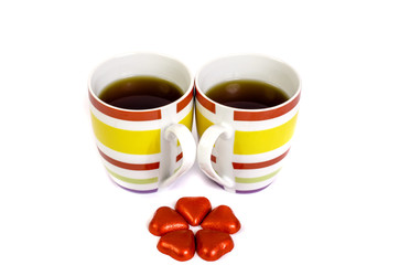 Two cups of tea and hearts on a white background.