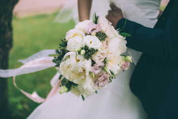 Beautiful wedding bouquet in hands of the bride