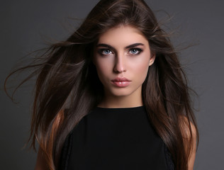 Fototapeta premium piękna, zmysłowa kobieta o ciemnych prostych włosach nosi eleganckie ubrania