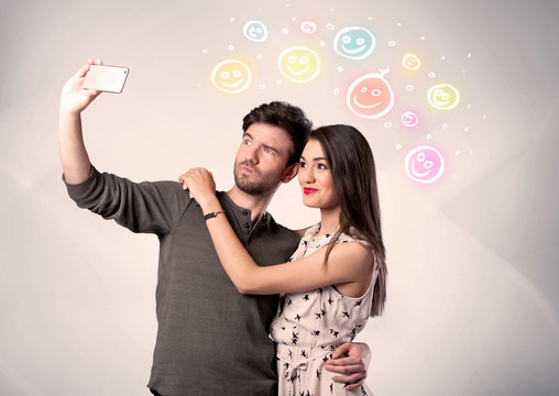 Happy couple taking selfie with smiley