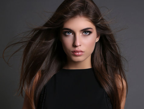 Fototapeta gorgeous sensual woman with dark straight hair wears elegant clothes