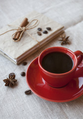 Red cup of coffee with coffee beans and spices cinnamon
