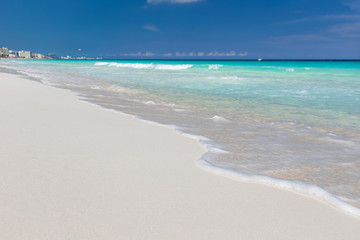Fototapeta na wymiar Sea waves with foam on white tropical sandy beach