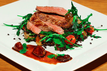 Delicious beef with lentils salad, arugula, tomatoes and garlic with sauce