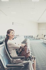 Fototapeta na wymiar 空港の待合室で座っている女性