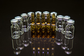 medical vials and syringe on black background