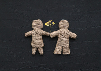 Boy and girl are made of hemp rope holding flowers. Be my valent