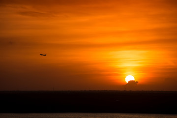 Fototapeta na wymiar Beautiful yellow sunset with airplane in the sky