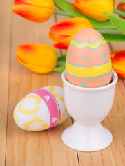 Easter Egg in a Cup With Tulips in Background