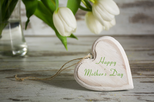 wooden heart shape an white tulips for mothers day