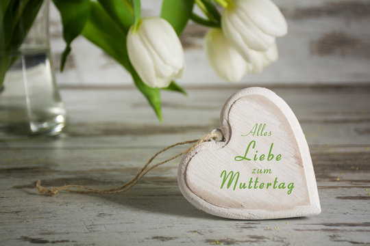 wooden heart shape and white tulips for Muttertag