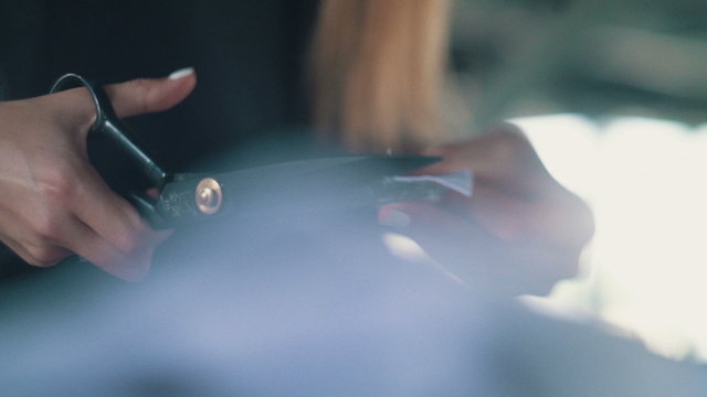 Designer cuts cloth with scissor, close up, tilt shift, dolly shot