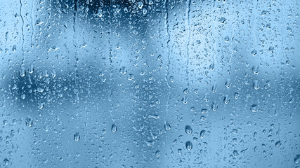 Raindrops on the window. Blue tone - obrazy, fototapety, plakaty