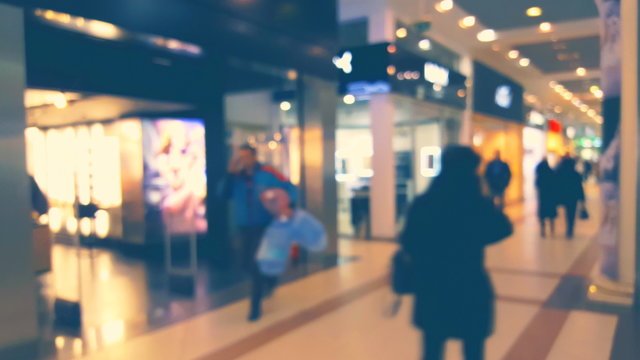 Blurred background window boutique shop interior with glowing lights and motion people