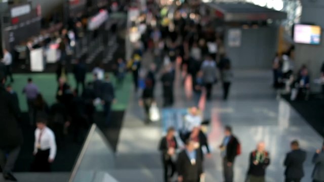 Out of focus shot of a busy building hallway, people walking about everywhere