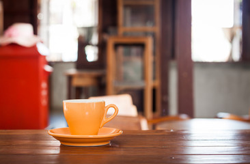Orange coffee cup on wooden table