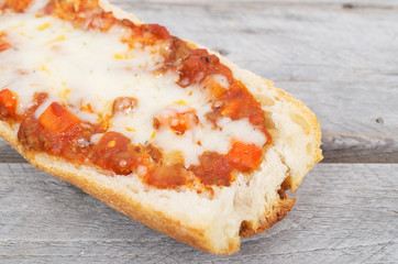 Toasted French baguette covered with meat sauce and cheese