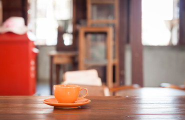 Fototapeta na wymiar Orange coffee cup on wooden table