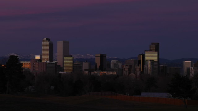 Sunrise in Denver, Colorado in winter, with brilliant pink clouds over the skyscrapers on the downtown skyline. HD 1080p time-lapse.