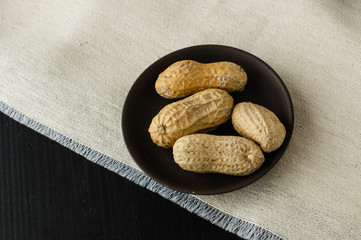 Peanuts in shell on a small ceramic plate