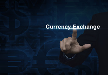 Businessman hand pushing currency exchange word on dark blue cur
