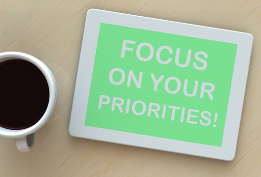 FOCUS ON YOUR PRIORITIES, message on tablet and coffee on table