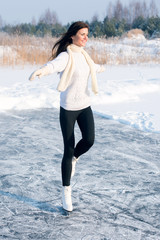 young Figure skating woman at the frozen lake in the winter