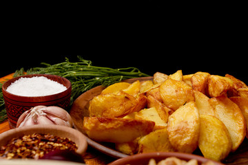 Potatoes fried in lard on black background