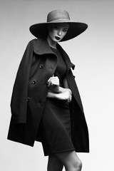 high fashion portrait of elegant woman in black  hat and coat.