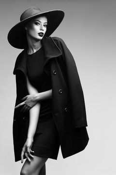 high fashion portrait of elegant woman in black  hat and coat.