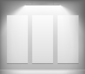 Three white canvas hanging on the wall.