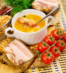 Pea soup with bacon. In white ceramic cup.