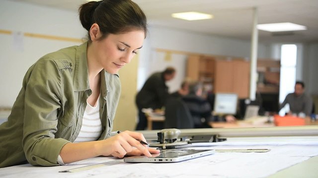 Woman architect working on drawing table in office
