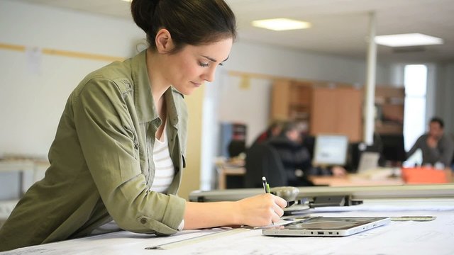 Woman architect working on drawing table in office