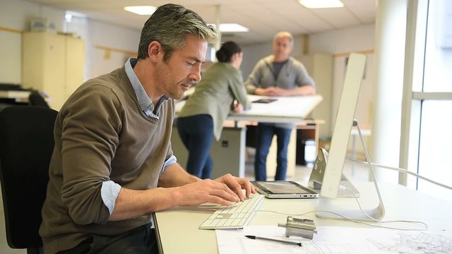 Engineer working in design office on desktop computer