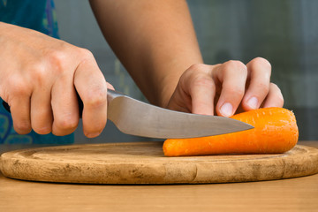 hands of woman cutting a carrot