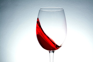 red wine in glass, splashing, splash, wave of red wine 
