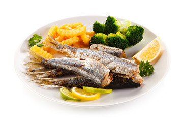 Fried herrings, chips and vegetables