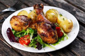 Baked chicken legs with potatoes and vegetables