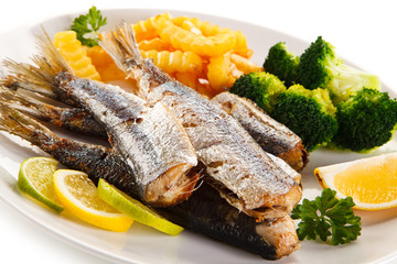 Fried herrings, chips and vegetables