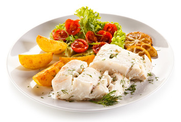 Fish dish -  boiled fish fillet, baked potatoes and vegetables 