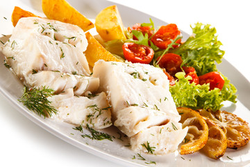 Fish dish -  boiled fish fillet, baked potatoes and vegetables 