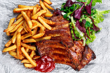 Roasted Pork Rib,  Fried Potato on white plate with Vegetables.
