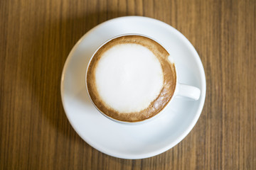 Hot Cappuccino with white cup on wood table coffee house