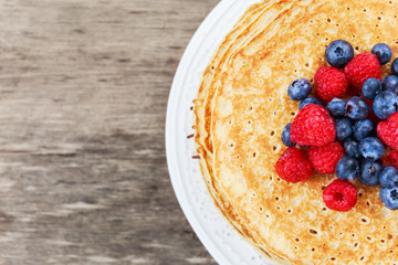 Fresh golden pancakes with raspberries, blueberries
