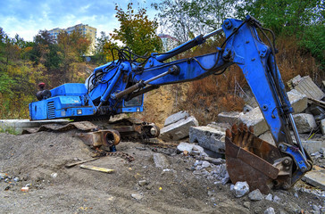 Broken excavator on a dump