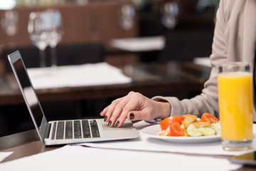 Pretty woman working with a notebook in restaurant