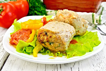 Cutlets of turkey with vegetables in plate on board