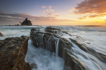 Beautiful sunrise at Kemasik beach during high tide and water flow.